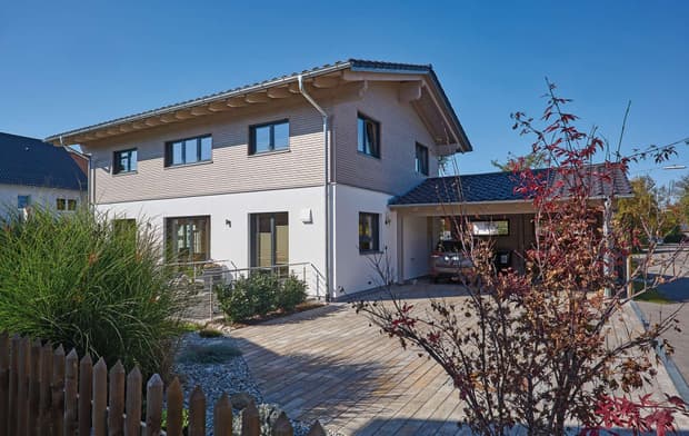 Modernes Holzhaus im Landhausstil mit Mischfassade aus mineralischem Putz und Holz