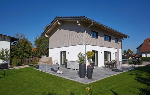 Modernes Holzhaus im Landhausstil mit Mischfassade aus mineralischem Putz und Holz