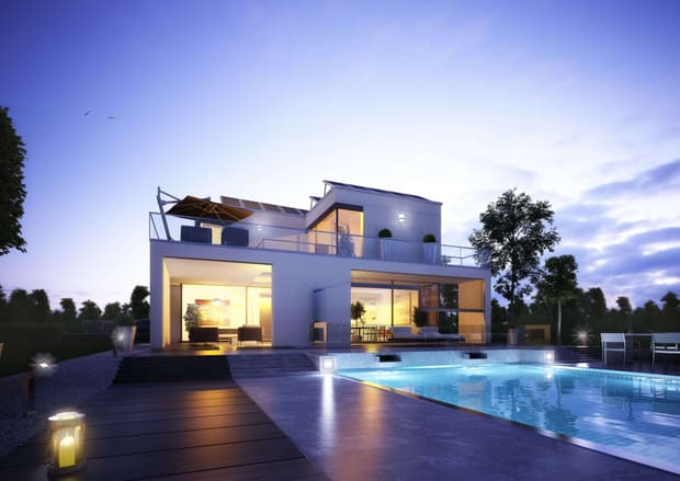 Modernes weißes Haus mit großer Terrasse und beleuchtetem Swimmingpool bei Sonnenuntergang in naturnaher Umgebung