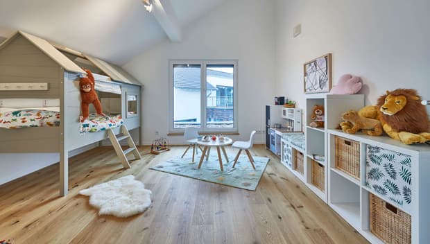 Helles Kinderzimmer mit Hochbett, Holzboden, Spielteppich, Regalen mit Körben, Kuscheltieren und großem Fenster.