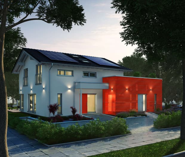 Modernes Einfamilienhaus mit rotem Anbau, Solarpanels auf dem Dach, großen Fenstern, Garten und stilvoller Beleuchtung.
