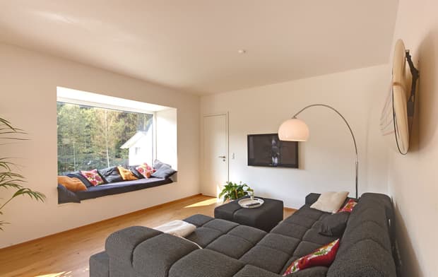 Das Wohnzimmer des Modernen Holzkubuses am Hang mit Holzfassade