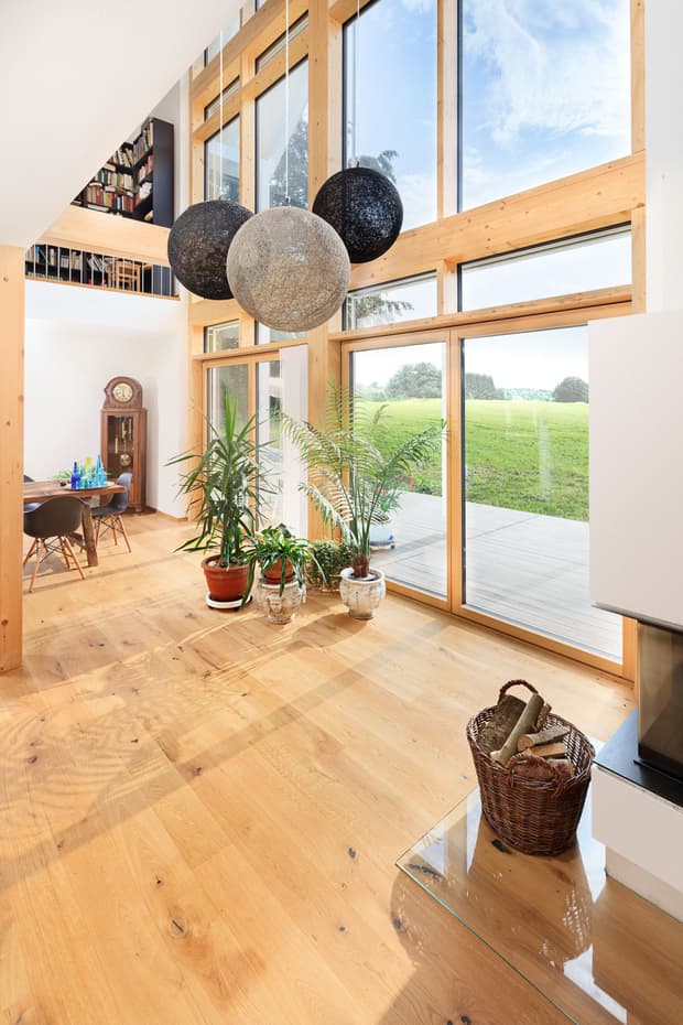 Heller Wohn- und Essbereich mit bodentiefen Fenstern und Holzboden