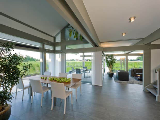 Offener Wohn-Essbereich mit Sichtbalken, bodentiefen Fenstern, Galerie, modernem Design und Terrassenzugang