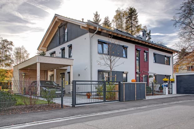 Der Eingang des modernen Zweifamilienhauses aus Holz mit Wintergarten