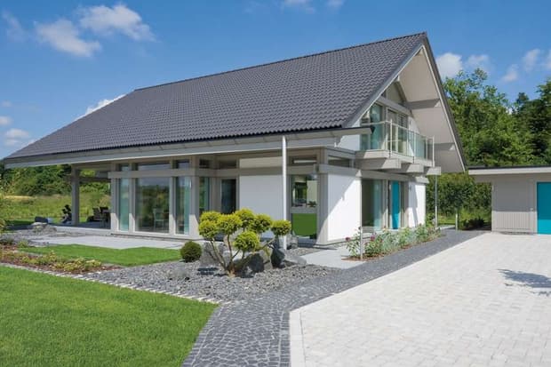 Modernes Einfamilienhaus mit Satteldach, großen Glasfronten, überdachter Terrasse, Garten und separater Garage