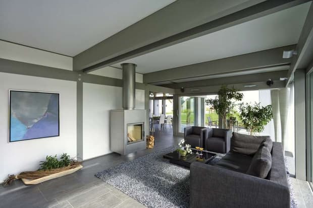 Modernes Wohnzimmer mit Kaminofen, Sichtbalken, offener Raumgestaltung, Designermöbeln und Panoramaverglasung