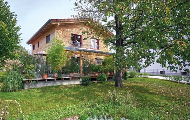 Modernes Holzhaus im Landhausstil mit durchgängiger Lärchenholzfassade und großer Terrasse