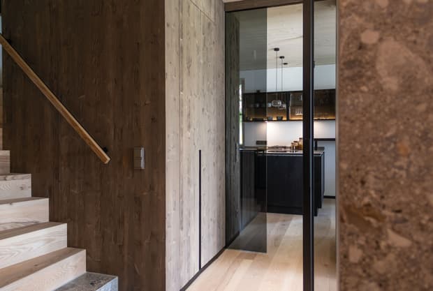 Die Diele samt Pivot Tür des modernen und großzügigen Holzhauses, bzw. Massivholzhauses im Landhausstil im Musterhauspark in Ortenburg. Der Neubau erinnert an die Chalets im Alpenvorland, hat aber viele moderne Designelemente.