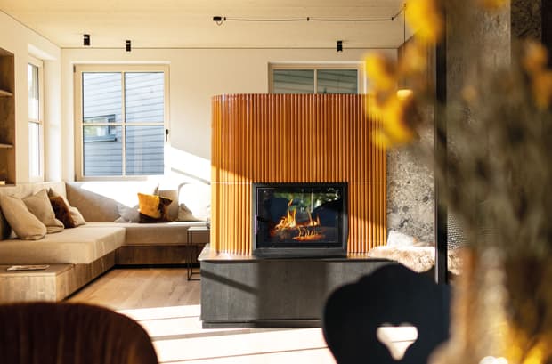 Der orangene Kamin des modernen und großzügigen Holzhauses, bzw. Massivholzhauses im Landhausstil im Musterhauspark in Ortenburg. Der Neubau erinnert an die Chalets im Alpenvorland, hat aber viele moderne Designelemente.