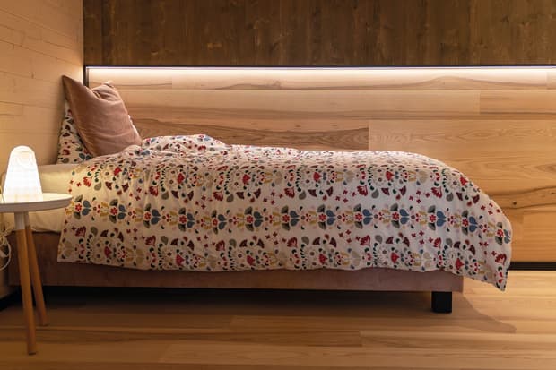 Das Bett mit Ambiente-Beleuchtung im Kinderzimmer des modernen und großzügigen Holzhauses, bzw. Massivholzhauses im Landhausstil im Musterhauspark in Ortenburg. Der Neubau erinnert an die Chalets im Alpenvorland, hat aber viele moderne Designelemente.