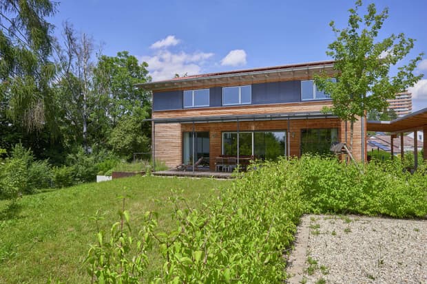 Modernes Holzhaus mit Lärchenholzfassade und Fassadenplatten in anthrazit