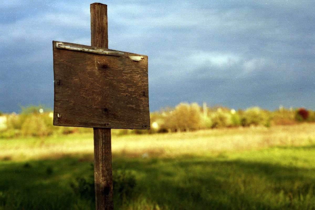 Leeres Grundstück mit Holzschild
