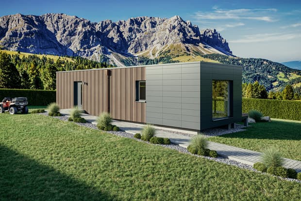 Modernes Einfamilienhaus mit Holz- und Metallfassade umgeben von Garten und Bergen im Hintergrund