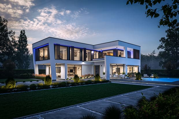 Modernes weißes Einfamilienhaus mit großflächigen Fenstern LED-Beleuchtung und Garten mit Swimmingpool bei Abenddämmerung