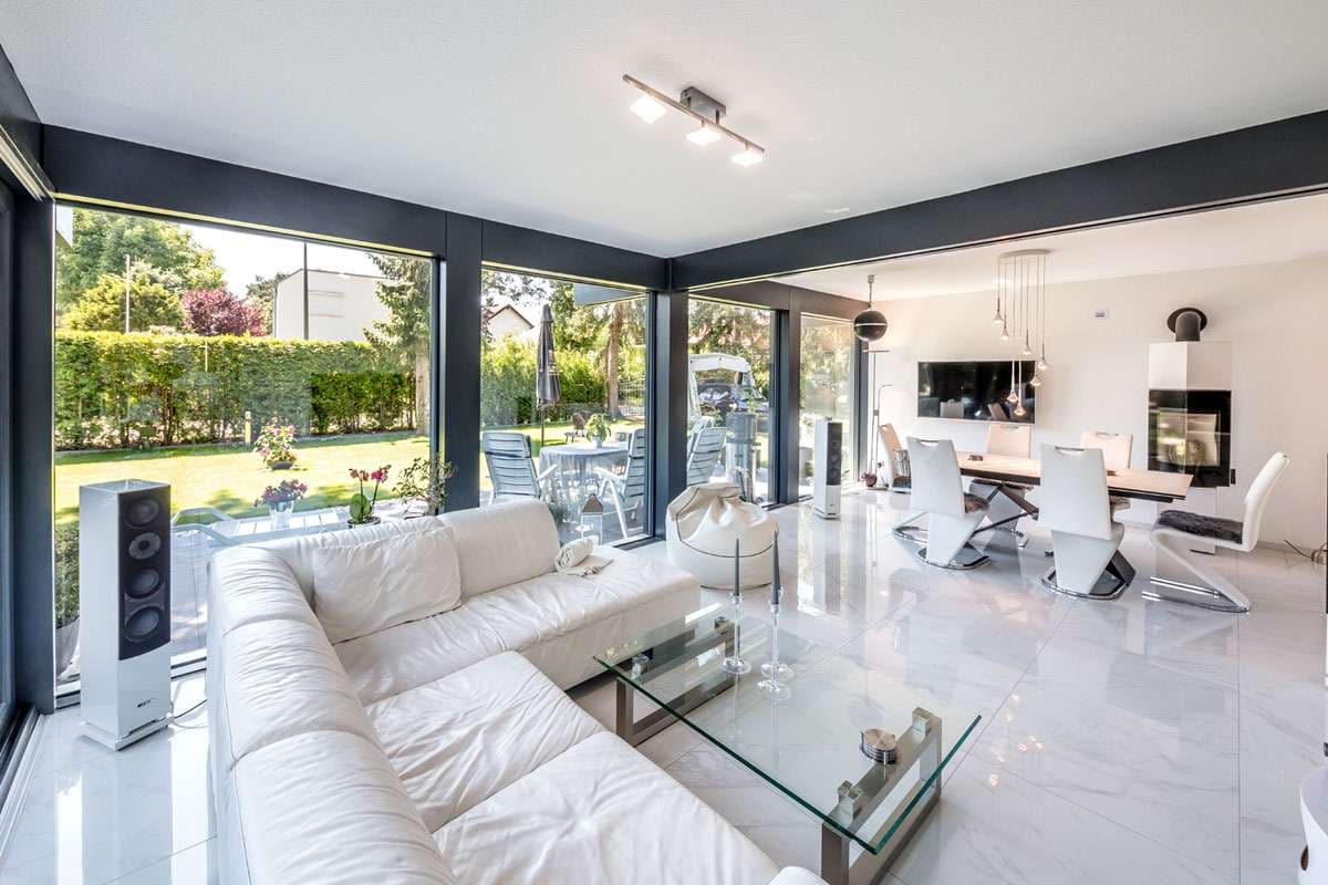 Offener Wohn- und Essbereich im modernen Stil mit verglaster Fassade