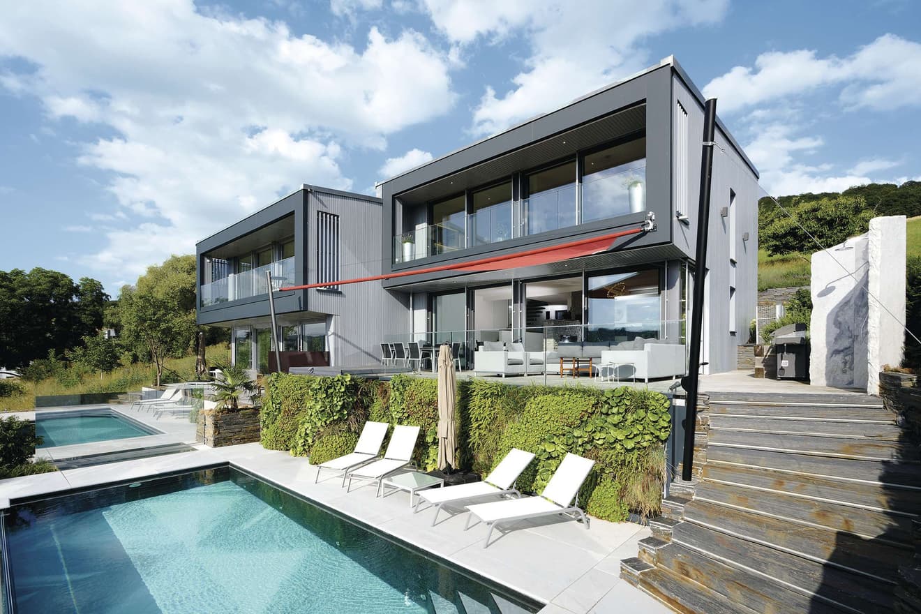 Kubisches Architektenhaus in Hanglage mit großen Panoramafronten mit Blick auf den Pool