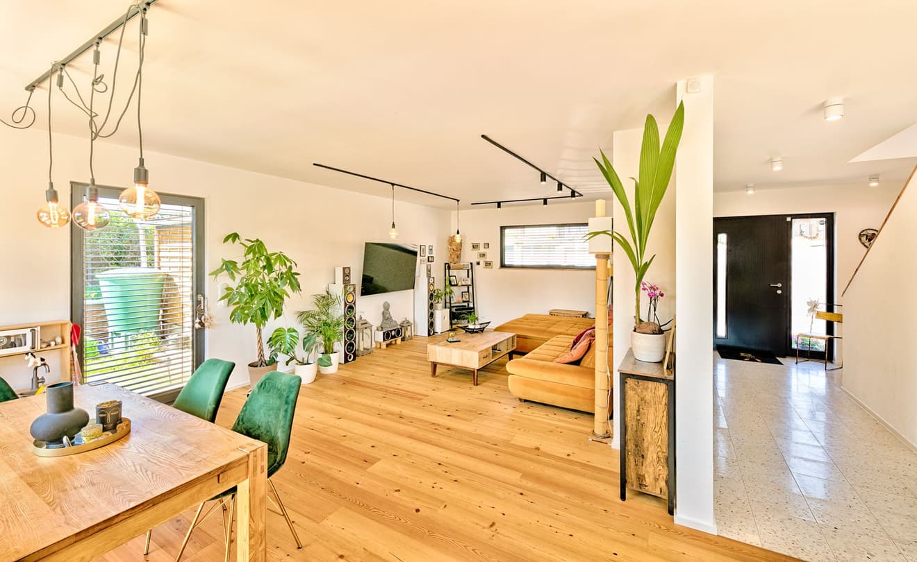 Offener Wohnbereich mit Holzparkett und Sofaecke