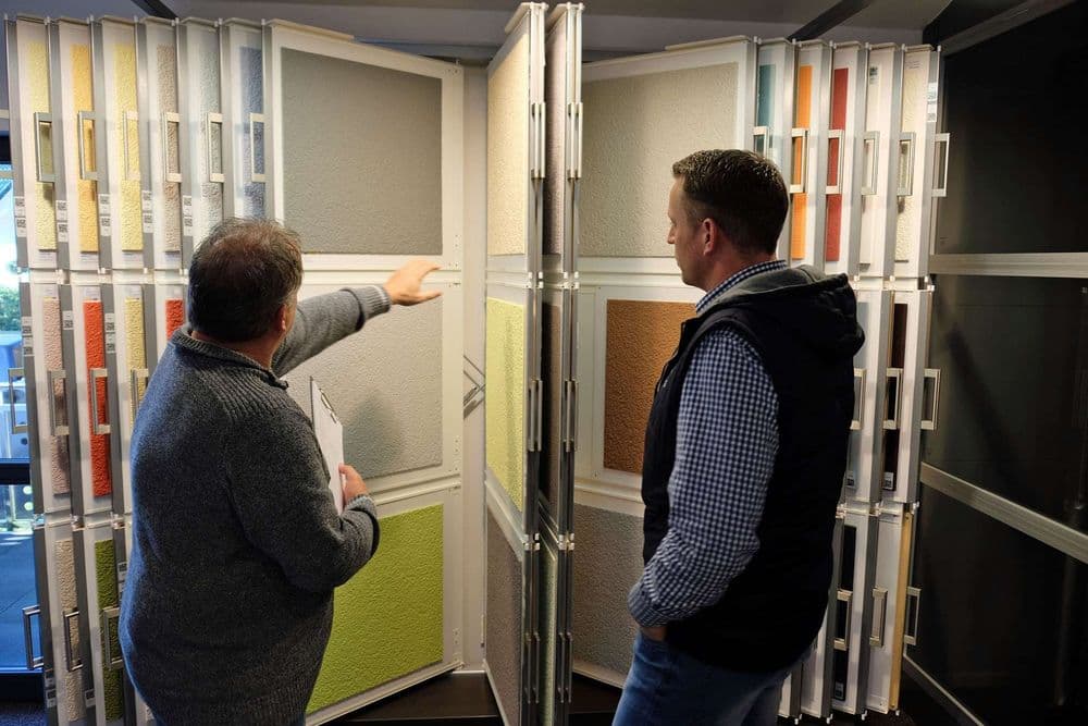 Bauherr bei der Besichtigung verschiedener Fassadenfarben 