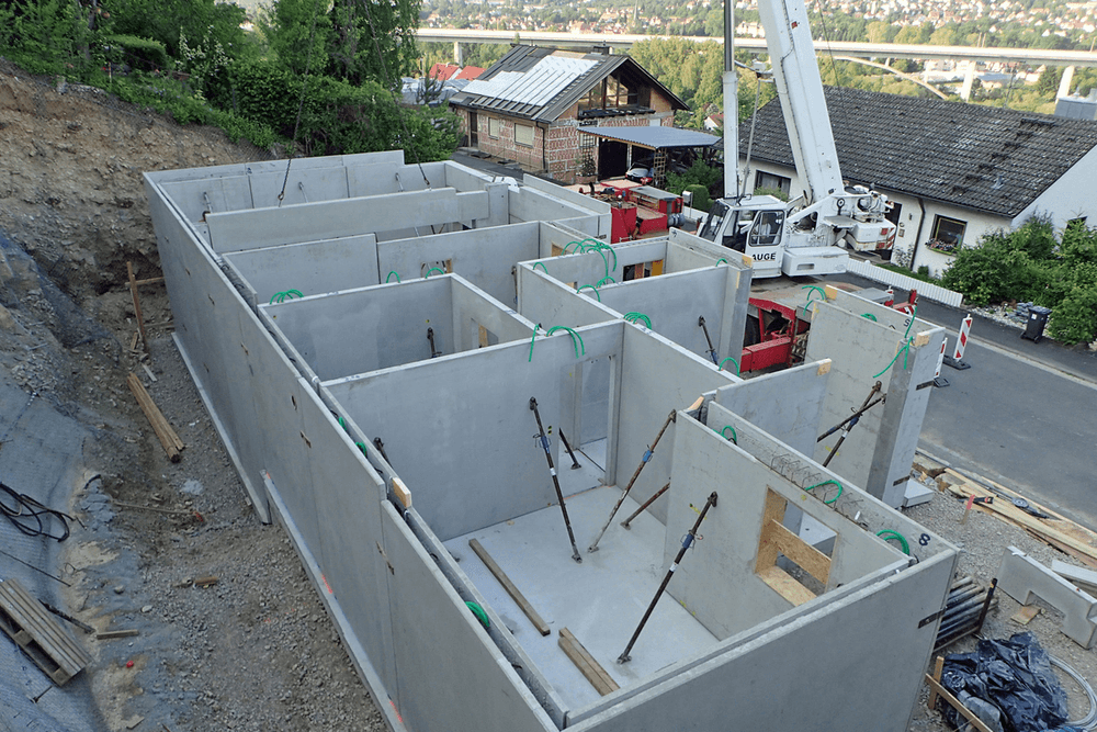Baustelle eines Fertighauses mit errichtetem Fertigkeller