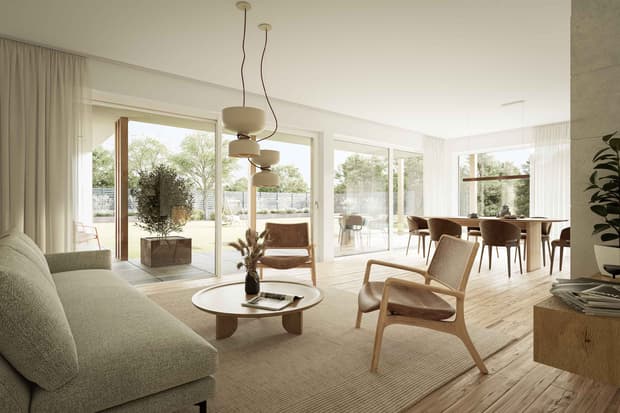 Offenes Wohnzimmer mit grauem Sofa, hellbraunen Lederstühlen, Holzboden und großer Glasfront zum Garten