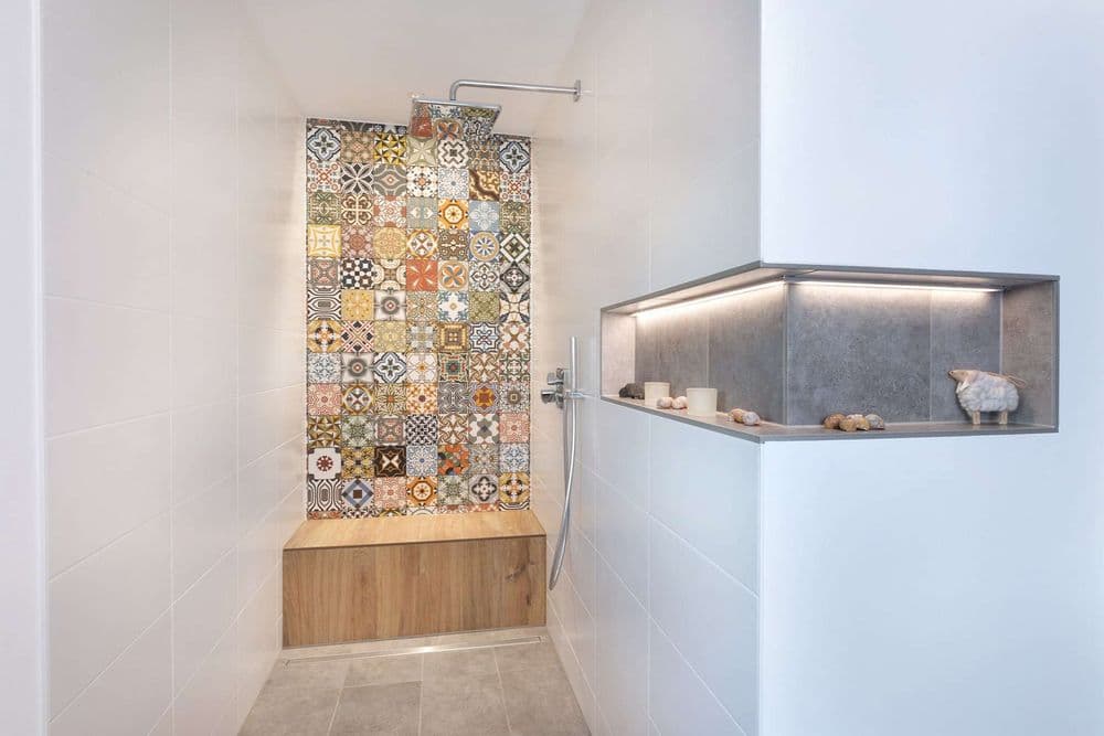 Offene Dusche mit Sitzbank aus Holz und Wandverzierung