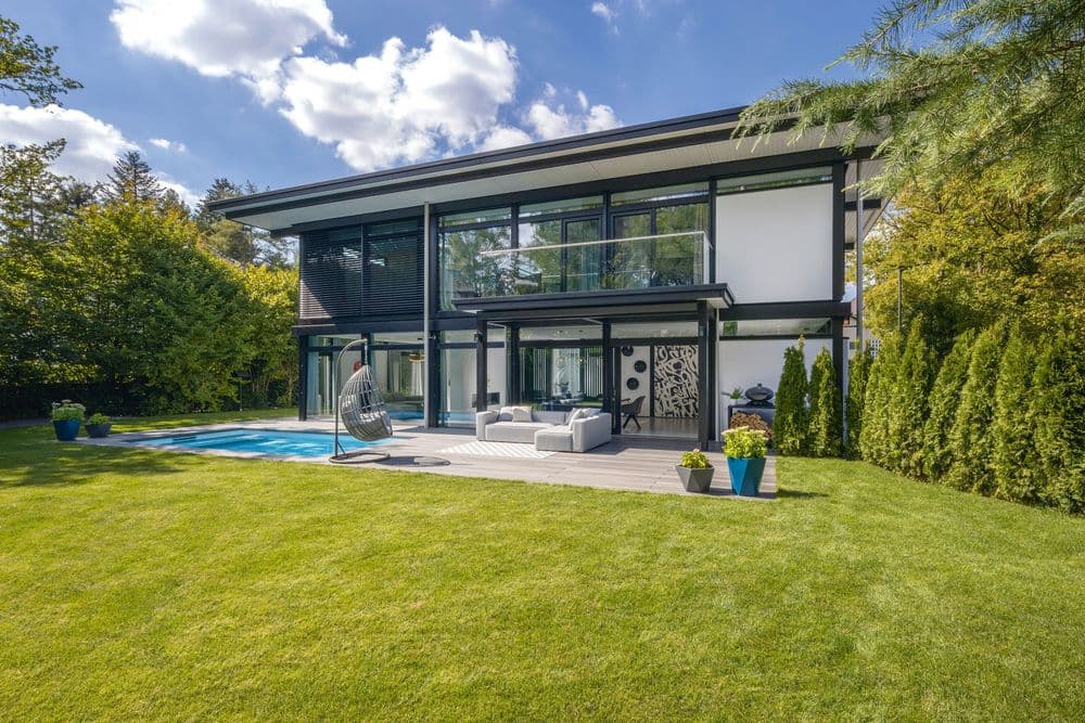 Modernes HUF HAUS im Bauhaus-Stil mit großem Garten und Pool