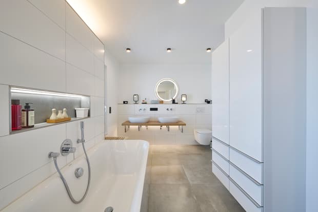 Modernes weißes Badezimmer mit freistehender Badewanne Spiegelschrank und Doppelwaschbecken mit Holzablage