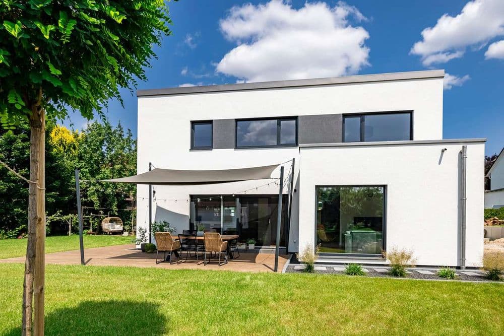 Modernes Fertighaus mit Putzfassade und Holzterrasse