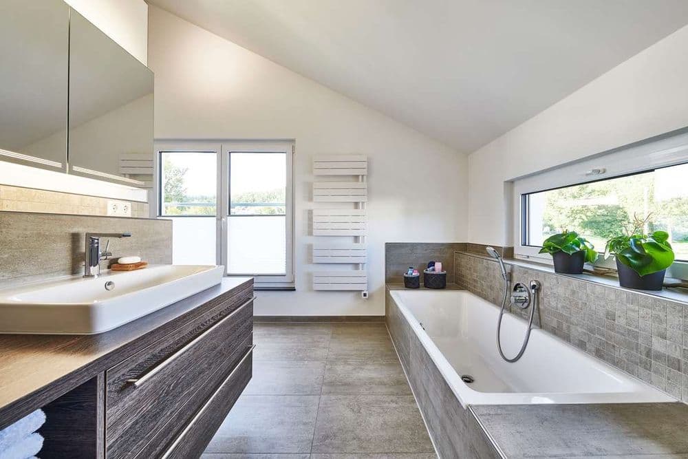 Großes Badezimmer mit Badewanne und Fensterband