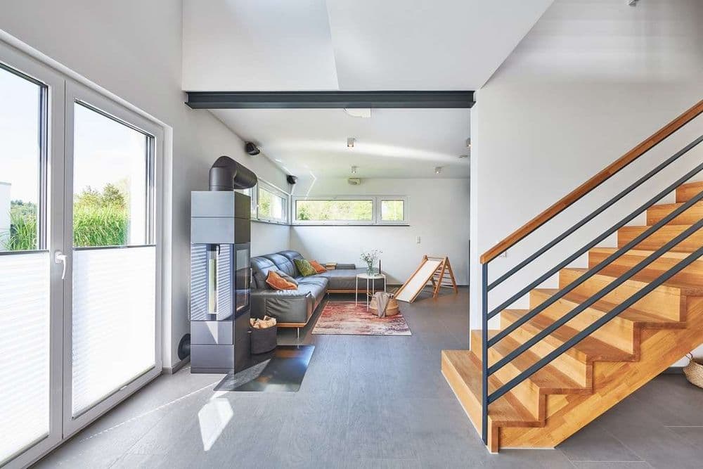 Wohnzimmer mit Kamin und Treppe ins Dachgeschoss