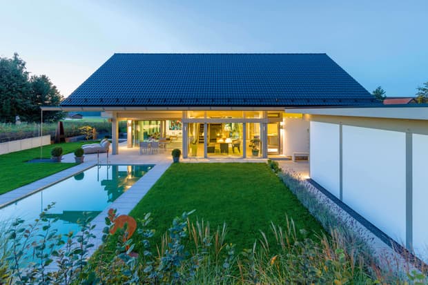 Holzhaus von HUF HAUS mit Garten und Pool