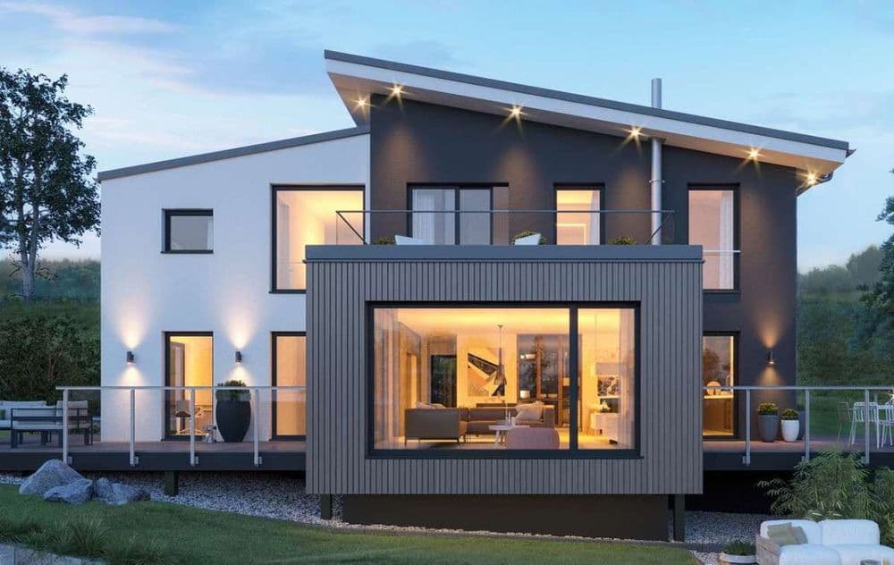 Modernes Fertighaus mit Pultdach und kubischem Anbau auf unebenem Grundstück