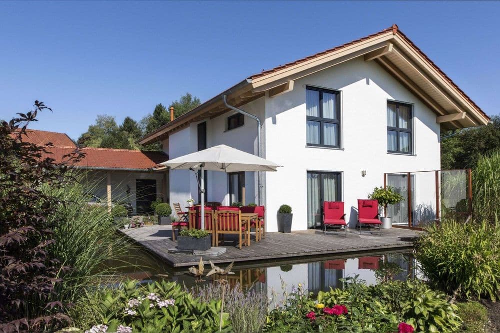 Modernes Fertighaus mit Satteldach, Terrasse und Gartenteich