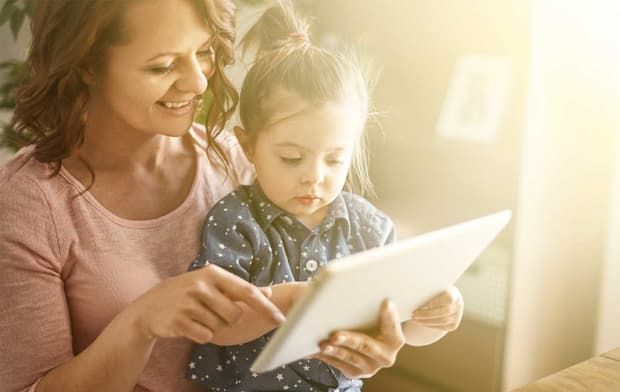 Frau und Kind gucken auf ein Tablet