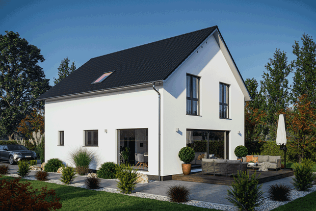 Modernes weißes Einfamilienhaus mit schwarzem Satteldach und Terrasse in grüner Wohngegend bei Sonnenschein