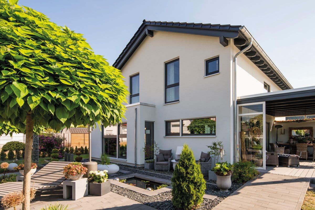Modernes Fertighaus mit Satteldach und überdachter Terrasse