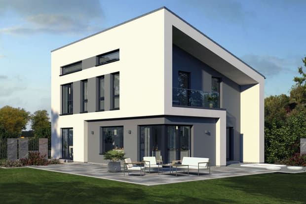 Modernes Musterhaus mit Flachdach, großer Fensterfront und Terrasse im Garten bei sonnigem Wetter.