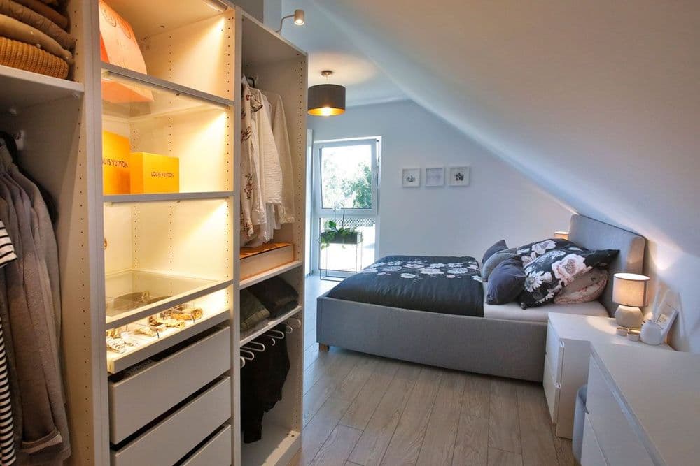 Schlafzimmer mit Dachschräge und beleuchtetem Kleiderschrank