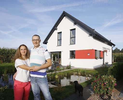 Baufamilie vor dem neuen Eigenheim