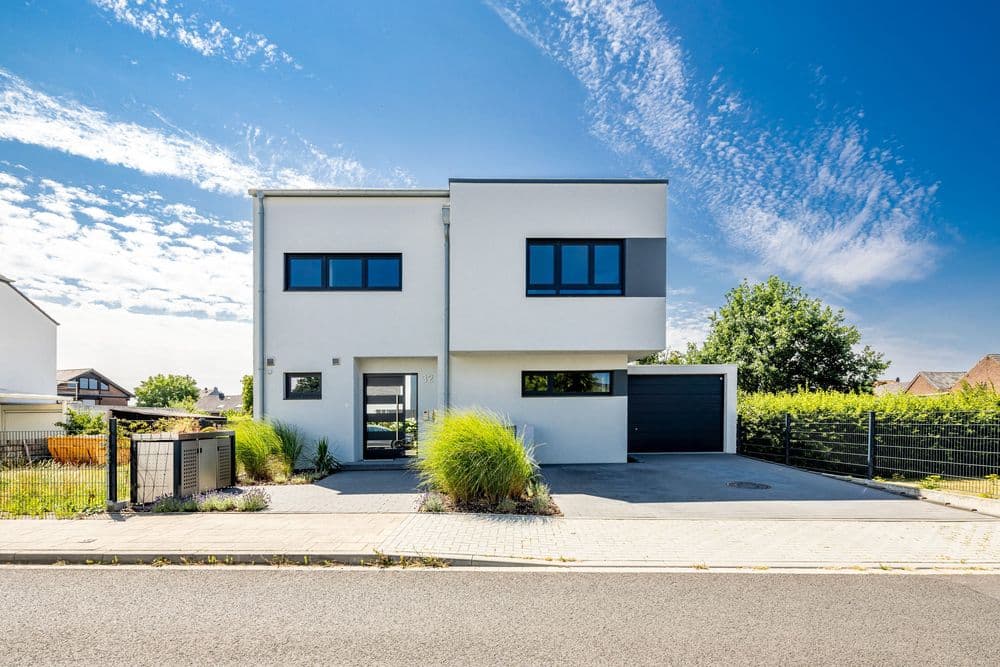 Modernes LUXHAUS Fertighaus mit Satteldach in Flachdach-Optik