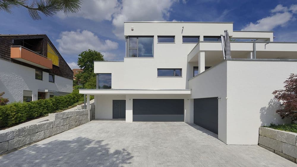 Eingangsbereich eines modernen Fertighauses am Hang mit Garage