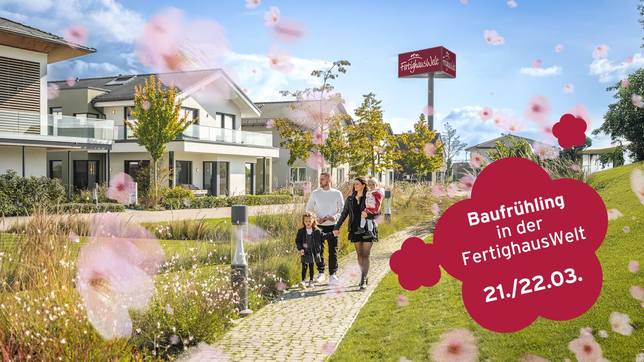 Familie spaziert durch modernen Musterhauspark mit Frühlingsblüten und Schild „Baufrühling 21./22.03.“.