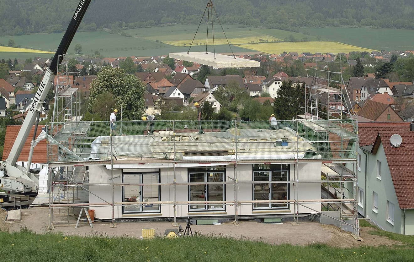 Rohbau eines Fertighauses mit Baugerüst und Kran