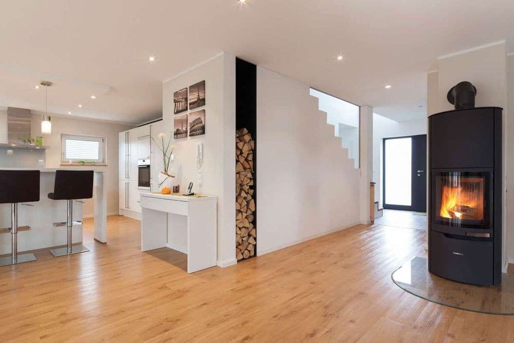 Offener Wohnbereich mit Kamin und eingebautem Schrank für das Kaminholz in der Treppe