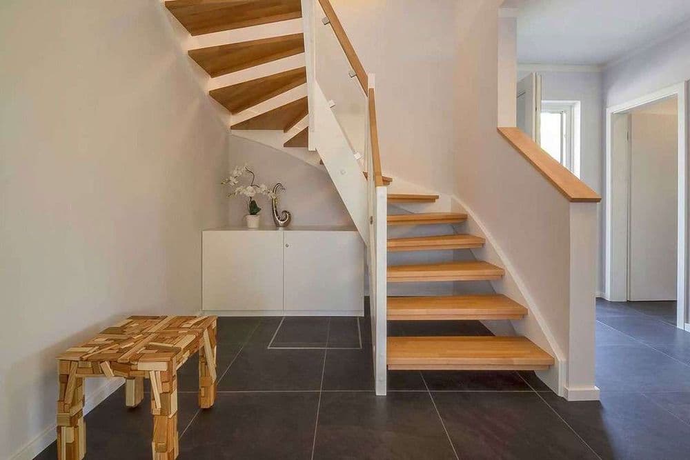 Gewundene Holztreppe mit schlichtem Sideboard