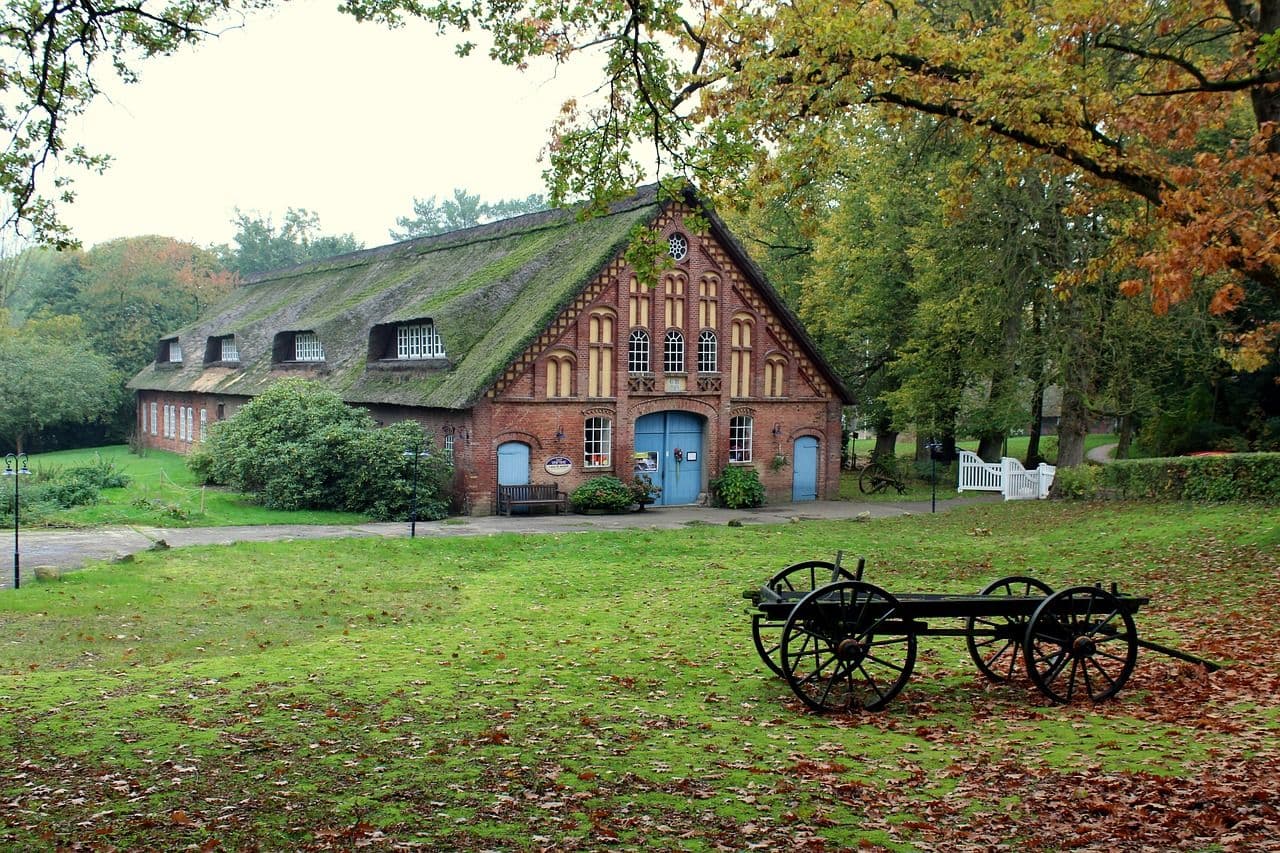 Altes Gehöft mit Bauernhaus und grüner Wiese