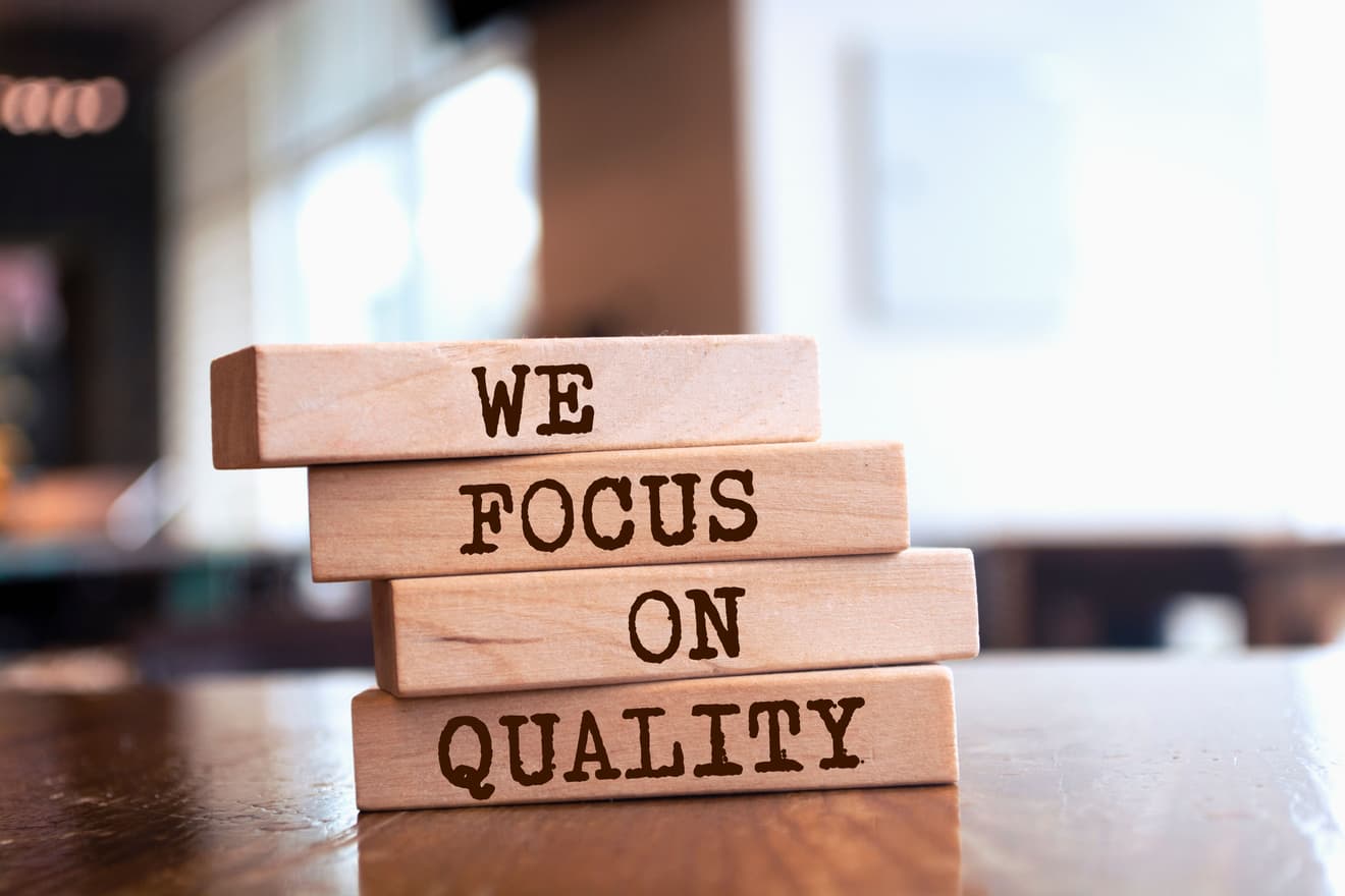Vier Holzblöcke, mit dem Schriftzug "we focus on quality"