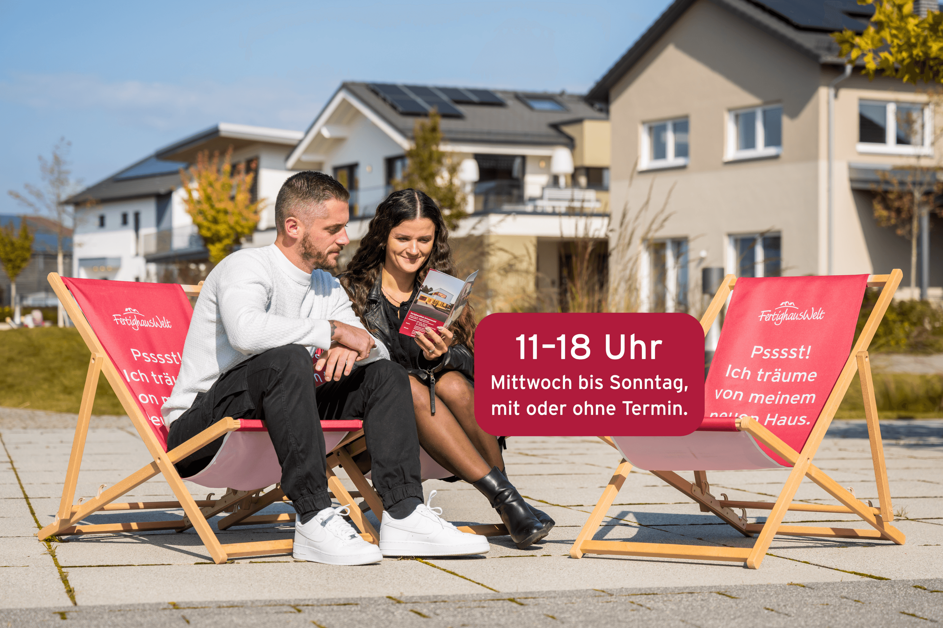  Paar auf Liegestühlen vor Musterhäusern, Schild zeigt Öffnungszeiten 11-18 Uhr, sonniger Tag