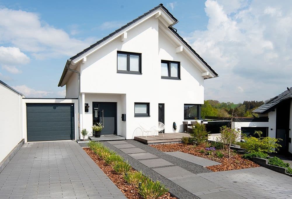 Außenansicht des modernen Einfamilienhauses mit Satteldach, Einfahrt und Garage